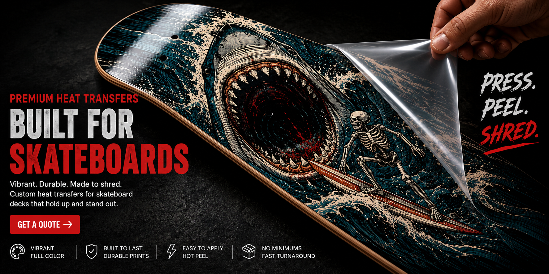 Glossy skateboard deck with a skeleton surfer and charging shark graphic as clear heat transfer carrier film is peeled away